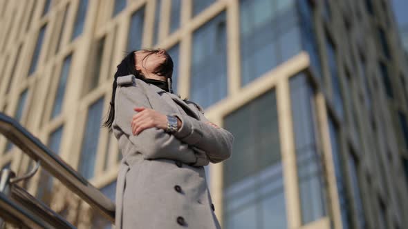 Successful Woman in Urban Landscape in Sunny Autumn Day Brunette is Standing Against High Building