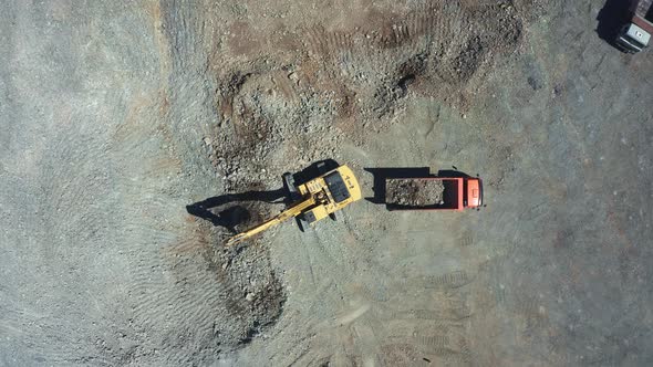 A Yellow Excavator Works in a Quarry