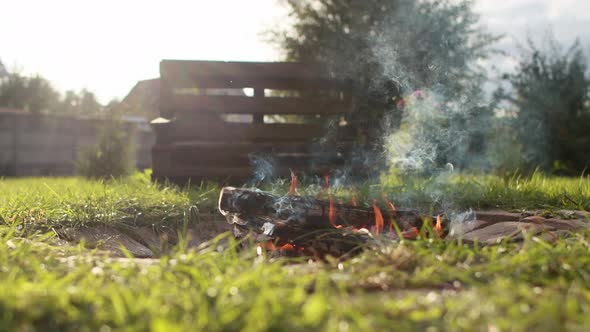 Bonfire at a Country Cottage on a Beautiful Summer Sunny Day in the Background