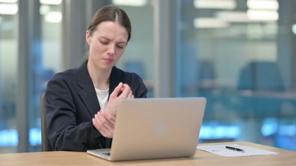 Young Businesswoman having Wrist Pain while Typing on Laptop