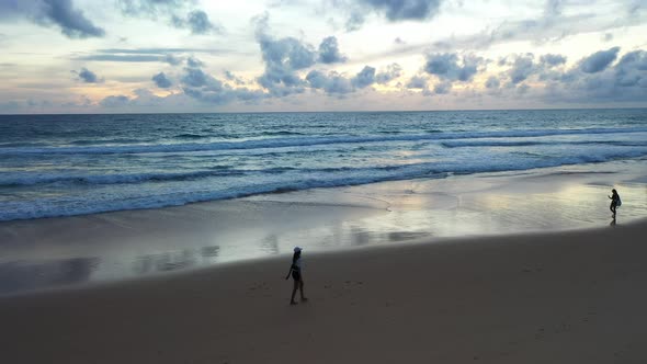 Womens Walking On The Beach In Sunset