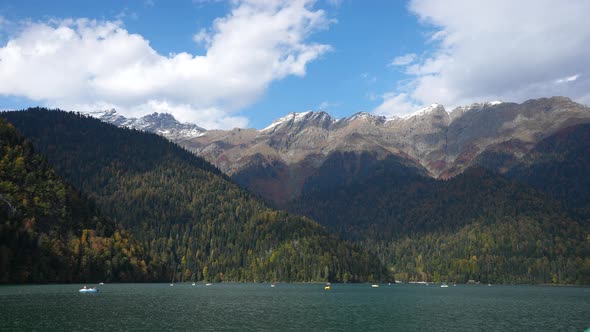 Timelaps of Moving Clouds in Sky and Boats Sailing on Mountain Lake Surface