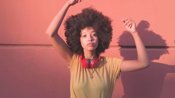 Young woman with red headphones doing her hair