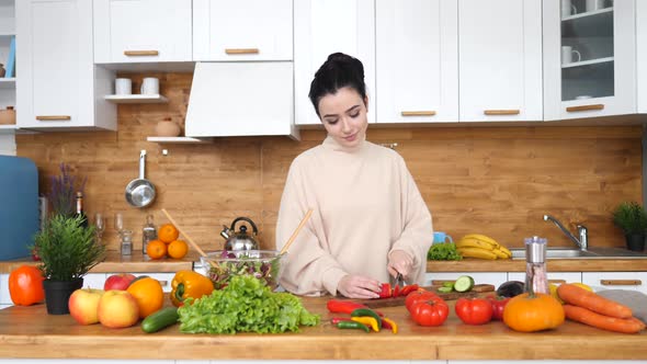 Healthy Lifestyle Concept. Young Female Cutting Vegetables For Salad In Kitchen.