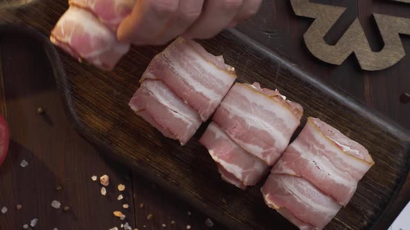 Chef Makes Rolls with Bacon and Chicken Chest on the Dark Wooden Board in the Kitchen, Close Up Shot