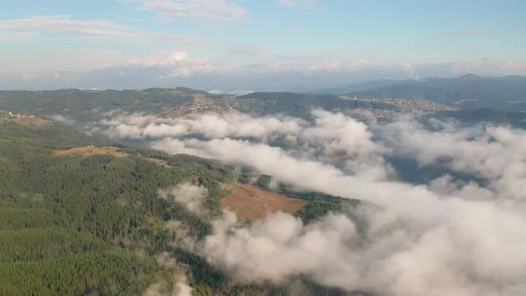 Drone flight over low clouds and morning mists
