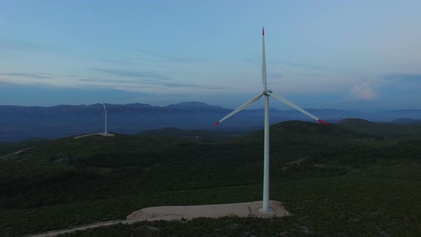 Aerial view of two windmills for the production of electric energy, at sunset