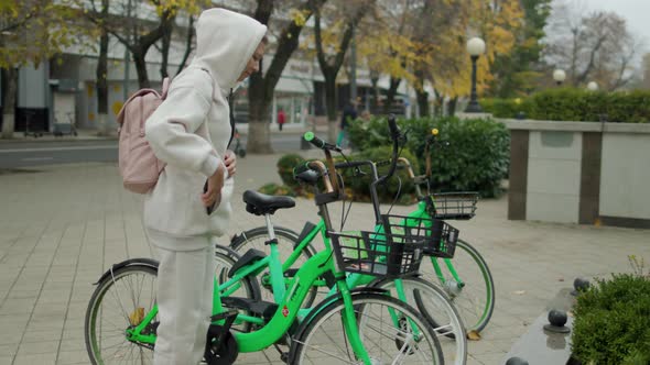 Woman Take Electric Kick Scooter Or Bike Bicycle In Sharing Parking Lot