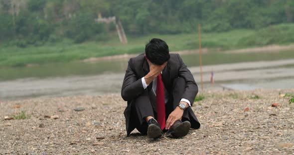 Businessman Sitting And Depressed Near River