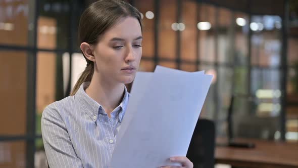 Young Woman Reading Documents Doing Paperwork