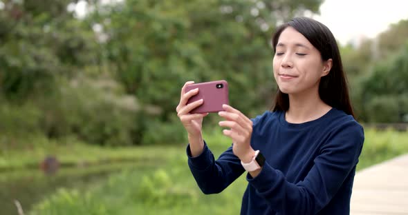 Woman taking photo with cellphone at outdoor