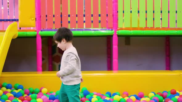 A 4Yearold Boy Plays in the Children's Pool with Balls in the Playroom Throws the Balls Up