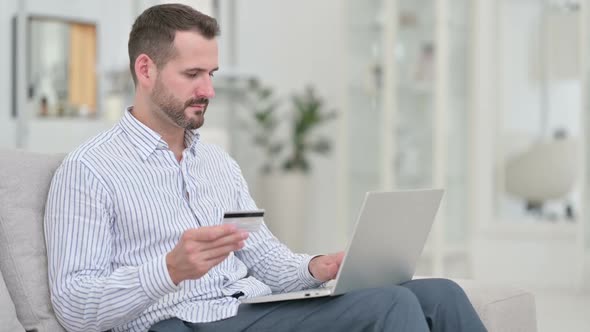 Successful Online Payment on Laptop By Young Man