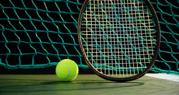 Tennis ball and racket against net in court 4k