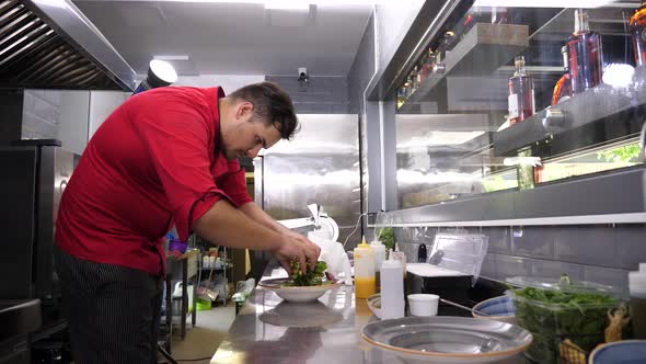 Cook in Restaurant Kitchen Preparing an Avocado Salad