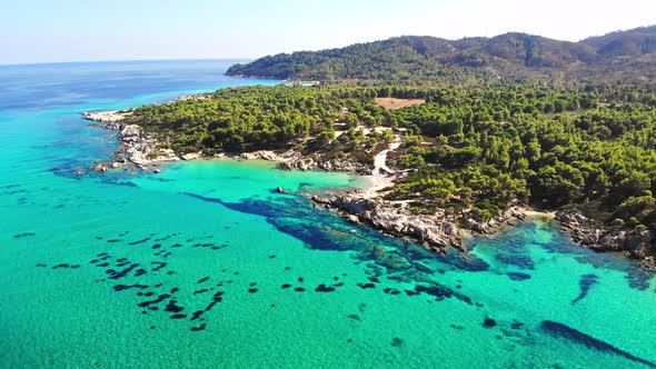 Aerial drone view of the Aegean sea rocky coast with blue transparent water