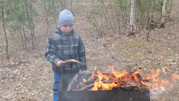Boy Cooks Food on the Fire in the Grill. Country rest