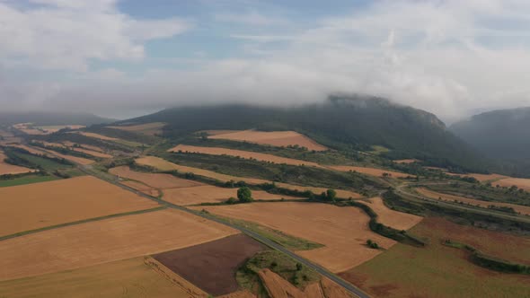 Agricultural fields near mountains under blue cloudy sky