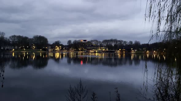 Static wide shot of calm lake during cloudy day in the evening. Beautiful lighting promenade with re