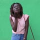 happy African-American woman dances and blows a kiss, on a green background - VideoHive Item for Sale