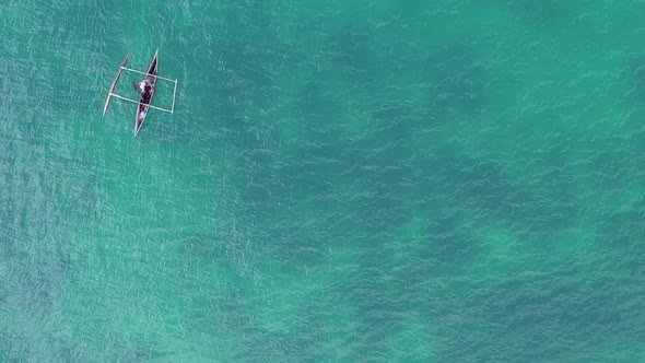 wide overhead aerial shot of small fishing dhow in the Indian Ocean off Madagascar