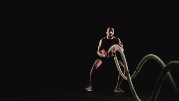 Athletic Man Training with Battle Ropes