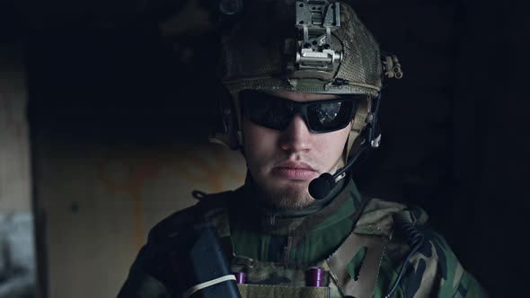 Close-up of a Professional Fully Equipped Soldier Looking at Camera.