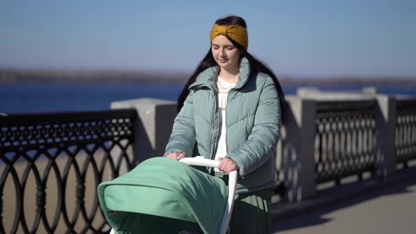 Woman Walking Through the Park with a Pram