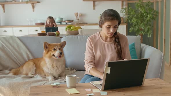 A Busy Annoyed Mother Working Remotely With a Laptop and Doing Business