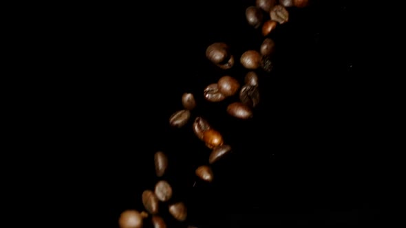 Roasted Caffeine-free Coffee Beans Falling Down Slow Motion Isolated on Black