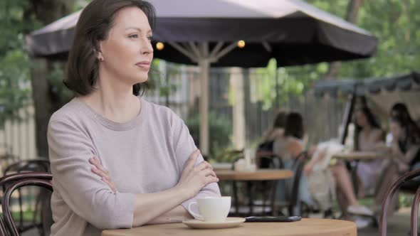 Smiling Old Woman Looking in Camera While Sitting in Outdoor Cafe