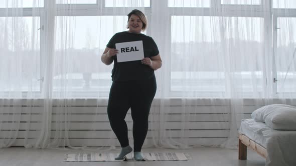 Concept Body Positivity  a Chubby Smiling Woman Holds a Sign with the Inscription REAL