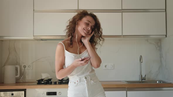 A Young Woman is Listening to Music and Dancing