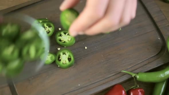 Slicing Jalapeno Pepper on a small cutting board.