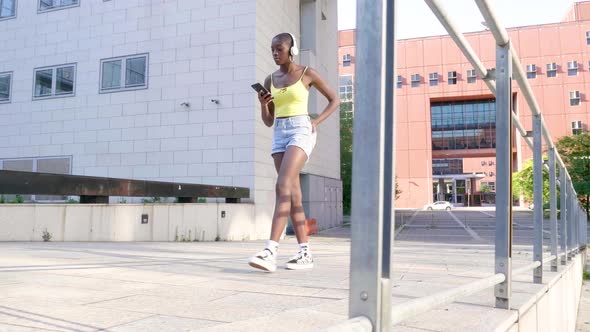 Slow motion shot of young woman using smartphone and walking in city