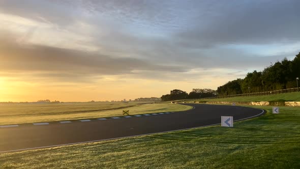 Camera panning left as the sun rises over an empty Goodwood race track