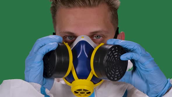Portrait of a Male Virologist in a White Protective Suit and Surgical Gloves Puts and Then Removes