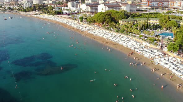 People Bathing in the Sun, Swimming on the Beach. Aerial View of Tourists on the Sand Beach.