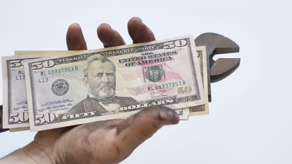 Technician with Dirty Hands Holding Wrench and Usd Bills in His