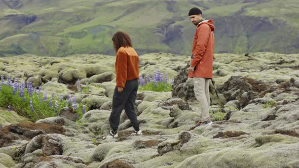 Couple Hiking over Rocks in Moss Covered Landscape