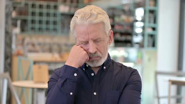 Sleeping Old Man While Sitting in Cafe