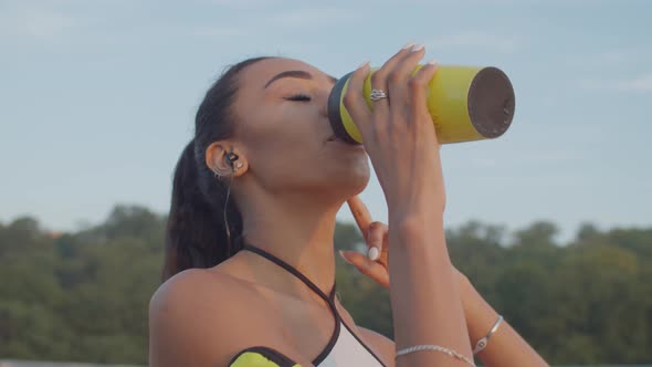 Black Sportswoman Drinking Water After Morning Jog