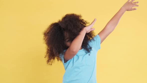 Funny Ridiculous African American Girl Posing on Yellow Background and Showing Dab Dance Pose Famous