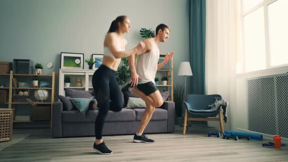 Young Girl and Guy in Sportswear Running at Home Doing Sports Together Training