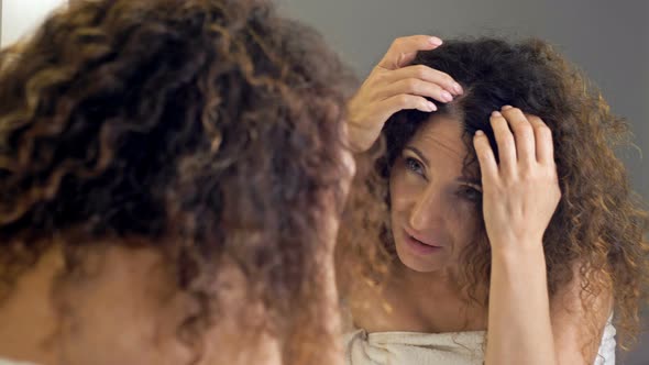 Beautiful Middleaged Woman Examines Her Gorgeous Hair in the Mirror