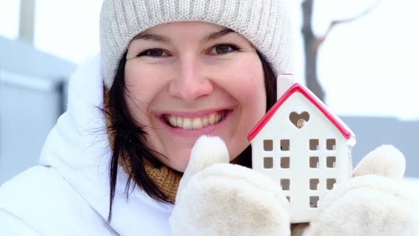 Happy woman in winter with symbol of home and love