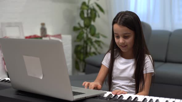 Christmas Time Laptop on Piano Keys Little Girl Playing Piano