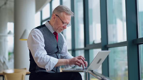 Freelance senior man working on a laptop. 