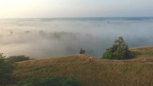 Young Couple of Tourists Walking on Top of Hill and Enjoying Spending Time Together at Beautiful