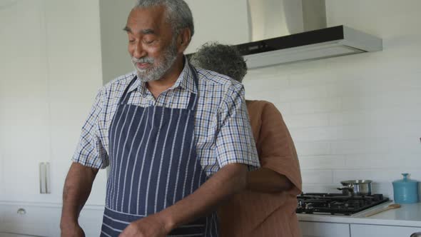 Animation of happy african american senior couple cooking together in kitchen